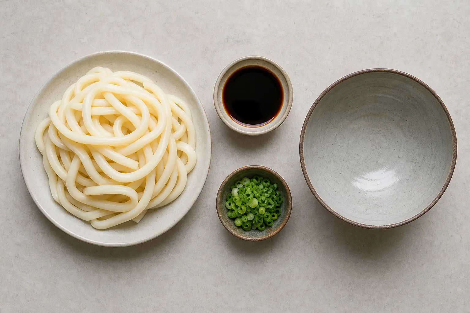 Thick udon noodles boiling long in a pot beside a small pot of dark tamari tare, ready to assemble Ise udon