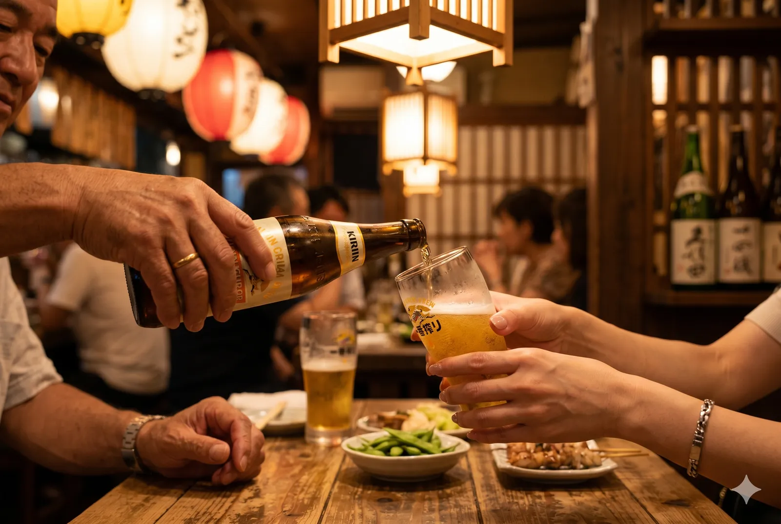 Two people pouring beer for each other at an izakaya table