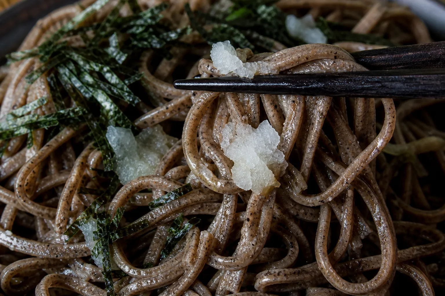 Close-up of dark izumo soba noodles topped with nori, daikon and green onion