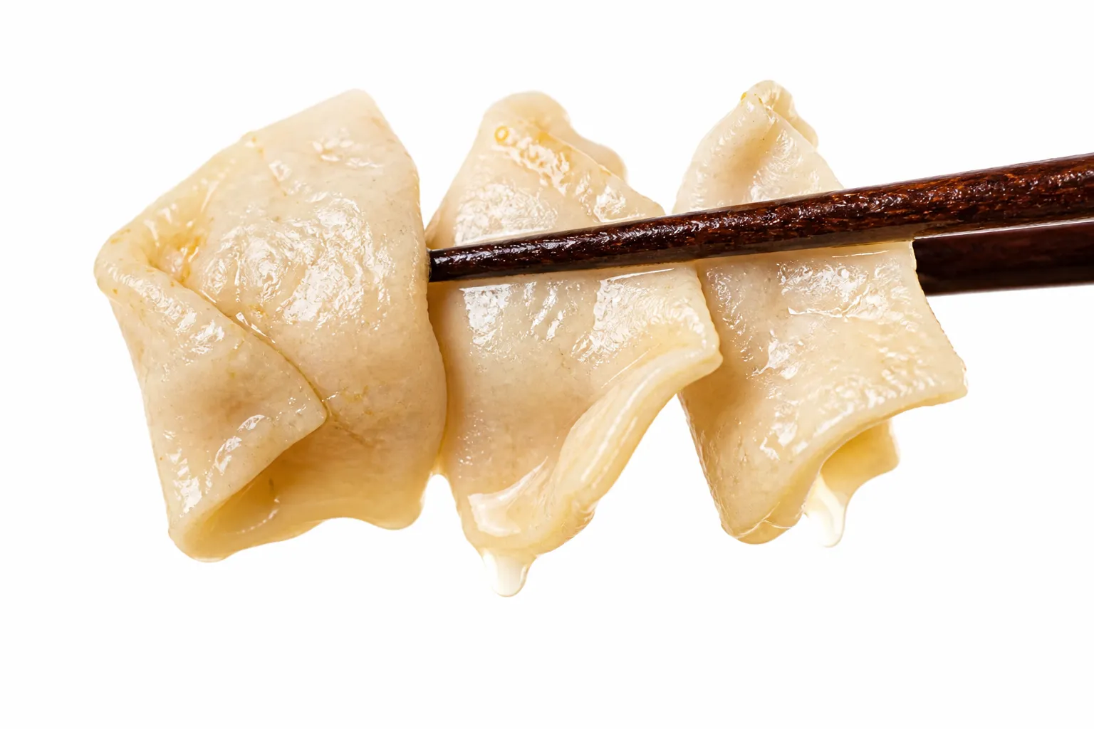 Close-up of flat ear-shaped mimi dough pieces lifted on chopsticks from miso broth