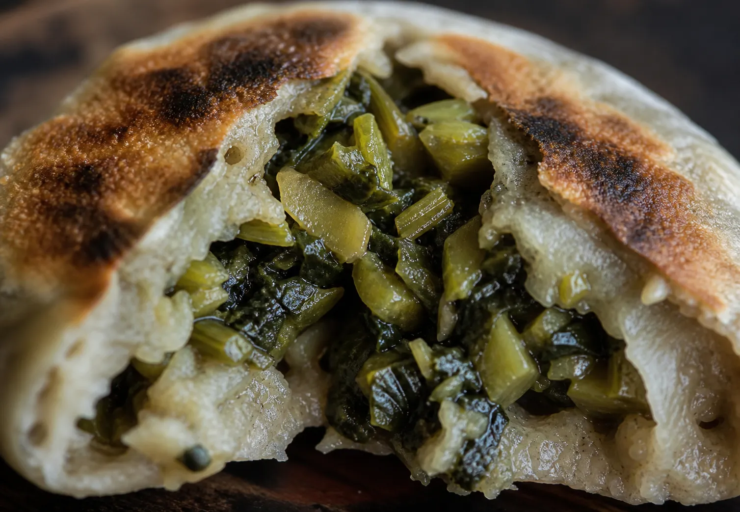 An oyaki torn open to show the chewy skin and savory pickled-greens filling