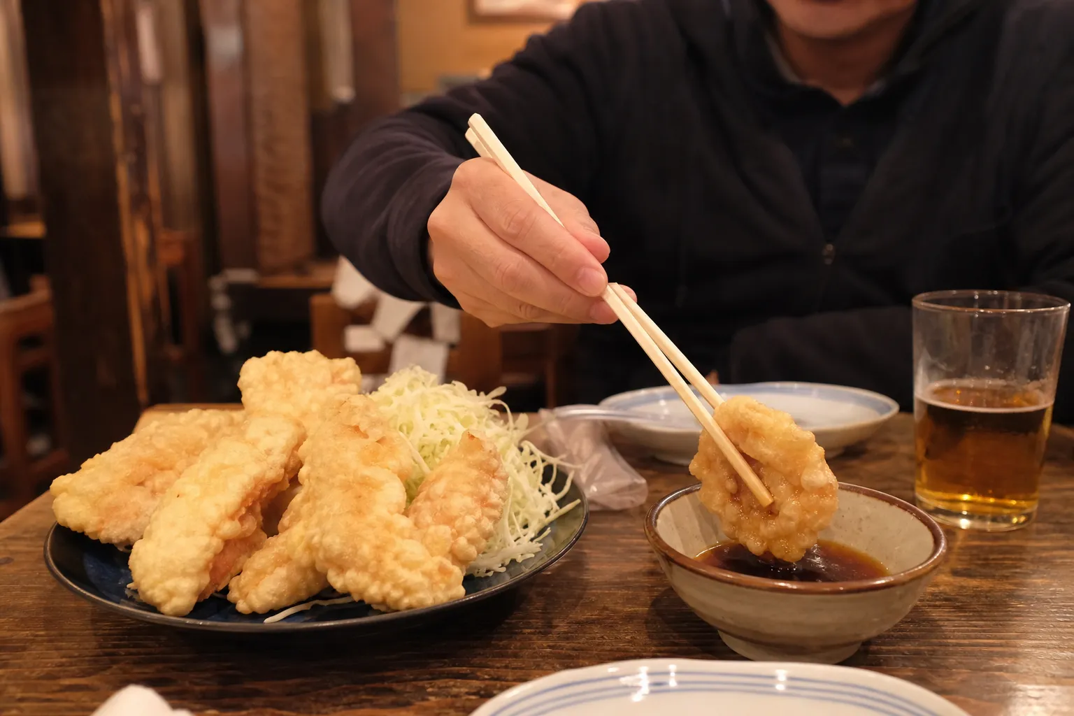 A plate of golden toriten with a dish of ponzu at a casual Oita restaurant