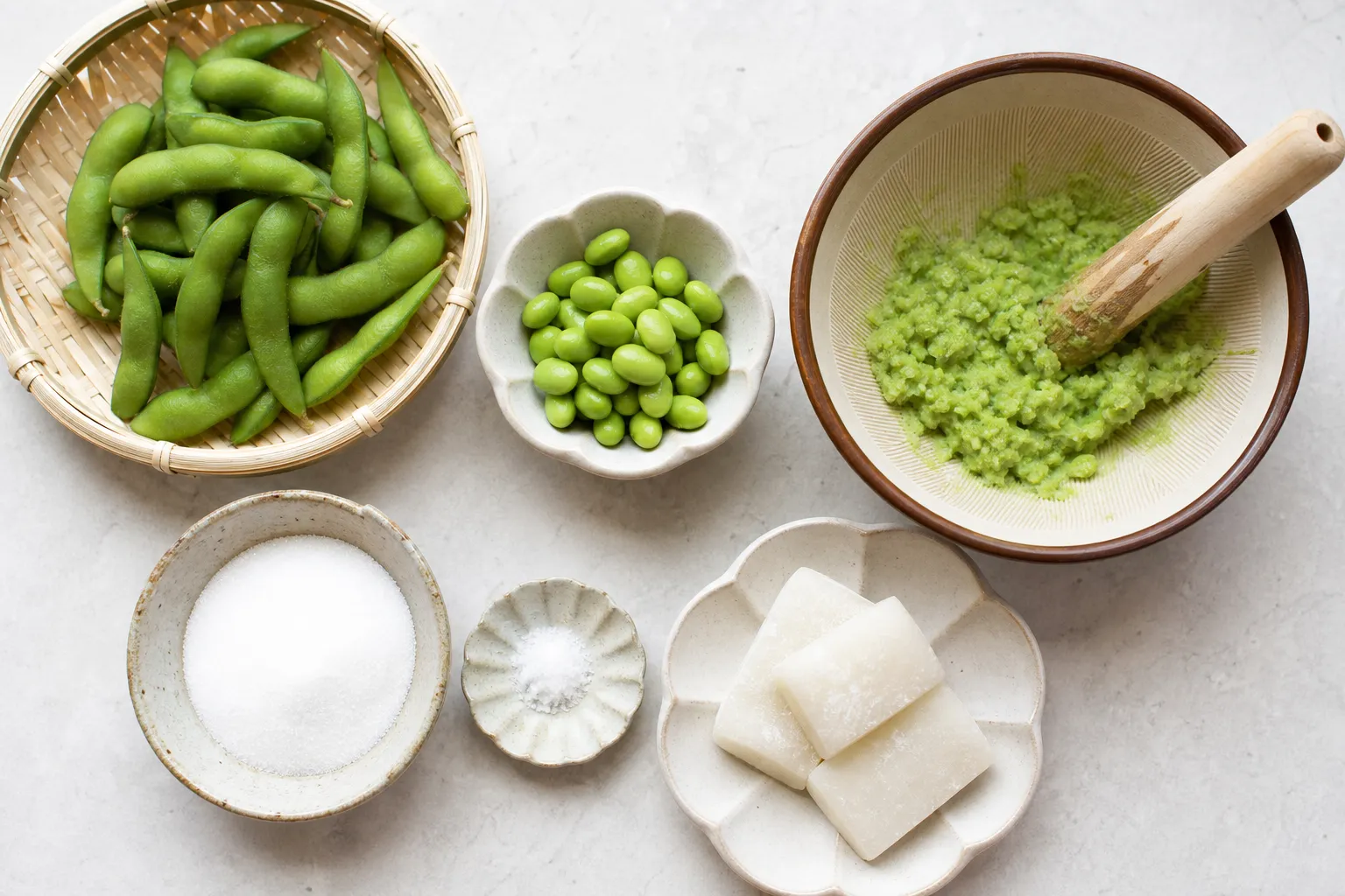 Zunda mochi ingredients: green edamame pods, shelled beans, mortar and pestle, mochi